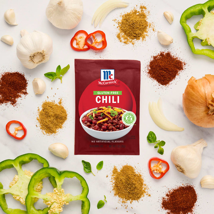 McCormick Chili seasoning packet surrounded by fresh ingredients like garlic, peppers, and spices.