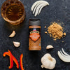 McCormick's Slow Cookers Brown Gravy seasoning mix is displayed with ingredients like garlic, onion, red pepper, brown sugar, and a glass of whiskey.