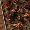 Dark, seasoned chicken drumsticks and thighs, cooked to perfection on a wire rack over a baking sheet, highlight the delicious flavor of Mccormick Grill Mates Brown Sugar Bourbon Blend Gf 3.0 Oz.
