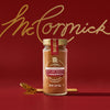 A jar of McCormick ground cinnamon is displayed against a red background with the McCormick logo in gold script.