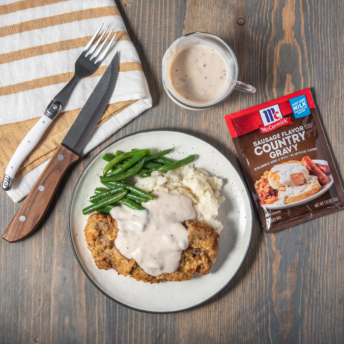 McCormick Sausage Flavor Country Gravy mix with a plate of chicken fried steak mashed potatoes green beans and gravy.