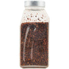 A clear plastic bottle filled with dried red pepper flakes.