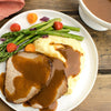 A plate of roast beef with mashed potatoes asparagus and gravy.
