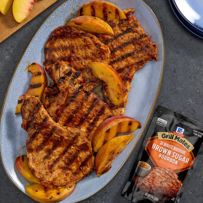 Grilled pork chops with peach slices, seasoned with McCormick Grill Mates Brown Sugar Bourbon seasoning.