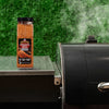 A container of Kosmos Q Dirty Bird BBQ Rub sits on a grill, suggesting its use in outdoor cooking.