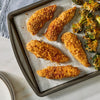 Crispy chicken tenders and cheesy broccoli on a gray plate are accompanied by a package of Mccormick Taco Seasoning Mix in the foreground.