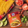 McCormick Mild Taco Seasoning Mix packet with taco shells tomatoes limes cilantro and shredded cheese.