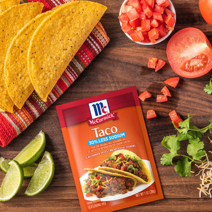 McCormick Taco Seasoning Mix with a taco tomatoes limes cilantro and cheese.