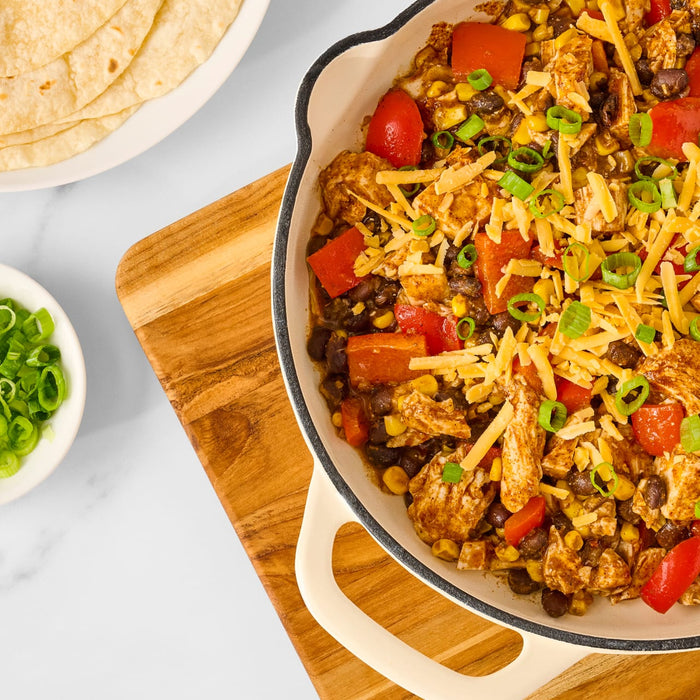 A delicious skillet of chicken taco filling, made with ingredients like black beans, corn, and peppers and seasoned with Mccormick Organics Regular Taco Seasoning Mix 1 Oz, is shown ready to be served with tortillas and fresh toppings.