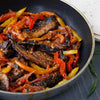 A skillet of delicious portobello mushroom fajitas made with Mccormick Organics Regular Fajita Seasoning Mix 1 Oz sits ready to be served with tortillas.