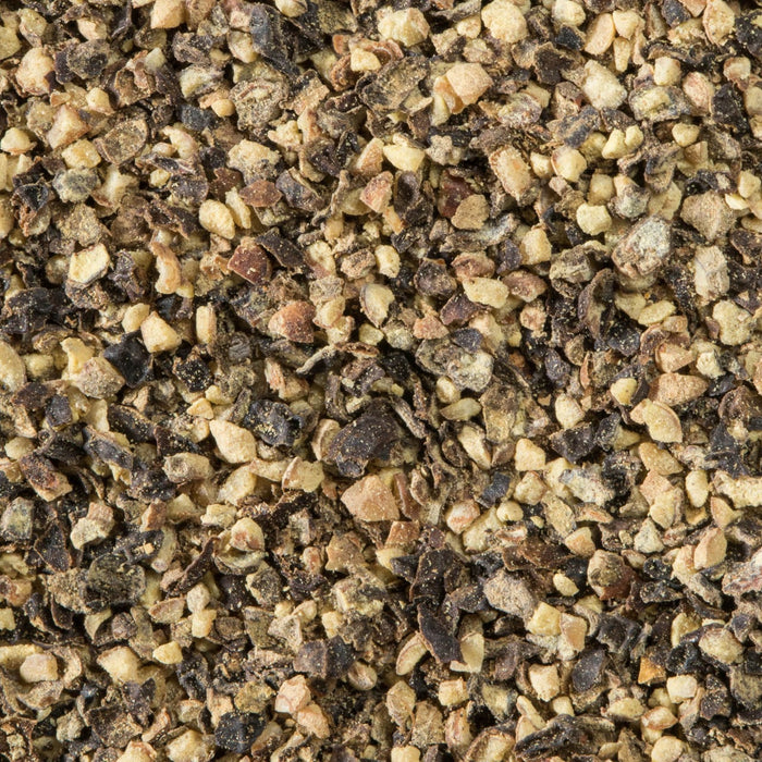 A close-up of coarsely ground black pepper, showcasing its texture and color.