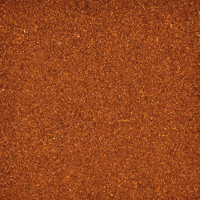A close-up texture of finely ground, reddish-brown spice.
