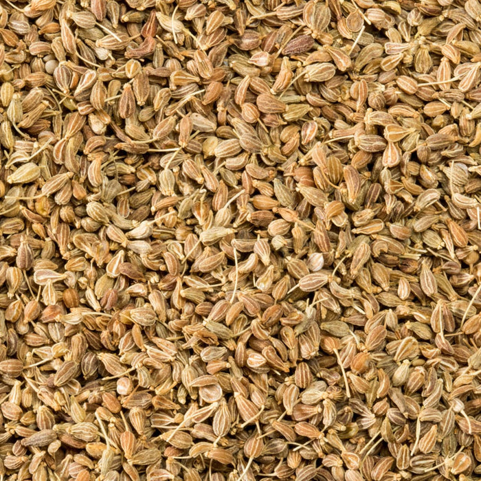 A close-up view of a pile of dried anise seeds, showcasing their distinctive shape and texture.