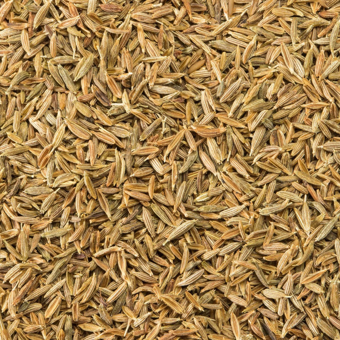 A close-up view of whole cumin seeds, showcasing their elongated shape and light brown color.
