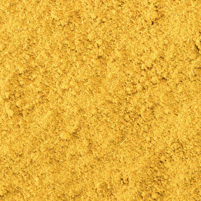 A close-up of a pile of yellow curry powder.