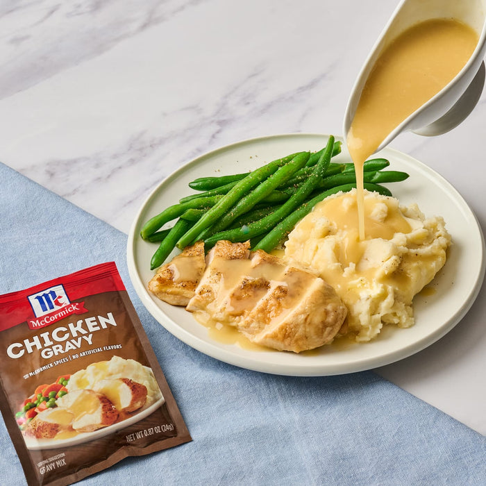 McCormick Chicken Gravy being poured over chicken mashed potatoes and green beans.