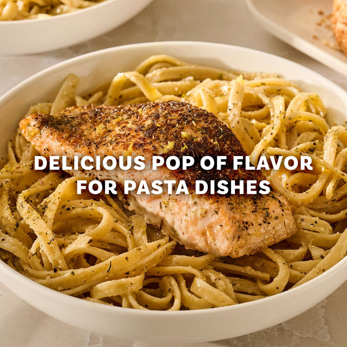 A seasoned salmon fillet rests atop a bowl of linguine pasta enhanced by Mccormick Garlic And Herb Pepper Seasoning Ground 4.37 Oz to provide a delicious pop of flavor.