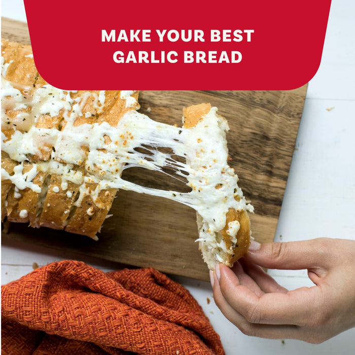 A hand pulls a cheesy slice of pull-apart bread seasoned with Mccormick Garlic And Herb Pepper Seasoning Ground 4.37 Oz from a wooden board.