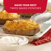 A close-up of steaming twice-baked potatoes topped with melted cheese and Mccormick Signature Seasoning Savory Garlic Onion Oz served with a side of creamy dipping sauce.