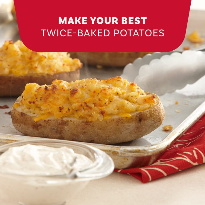A close-up of steaming twice-baked potatoes topped with melted cheese and Mccormick Signature Seasoning Savory Garlic Onion Oz served with a side of creamy dipping sauce.