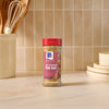 A bottle of Mccormick Himalayan Pink Salt Pepper And Garlic Seasoning Ground 6.5 Oz stands on a marble countertop in a bright kitchen setting.