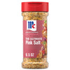 A clear plastic bottle of Mccormick Himalayan Pink Salt Pepper And Garlic Seasoning Ground 6.5 Oz featuring a red flip-top lid and a label showing roasted meat and vegetables.