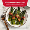 A plate of bacon wrapped asparagus bundles seasoned with Mccormick Himalayan Pink Salt Pepper And Garlic Seasoning Ground 6.5 Oz as a perfectly bundled side dish.