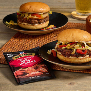 Two delicious burgers made with Hormel Real Bacon Crumbles are displayed on plates, showcasing a tasty meal option.