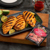 Grilled chicken breasts with lime wedges and McCormick Sweet &amp; Smoky Sriracha seasoning packet.
