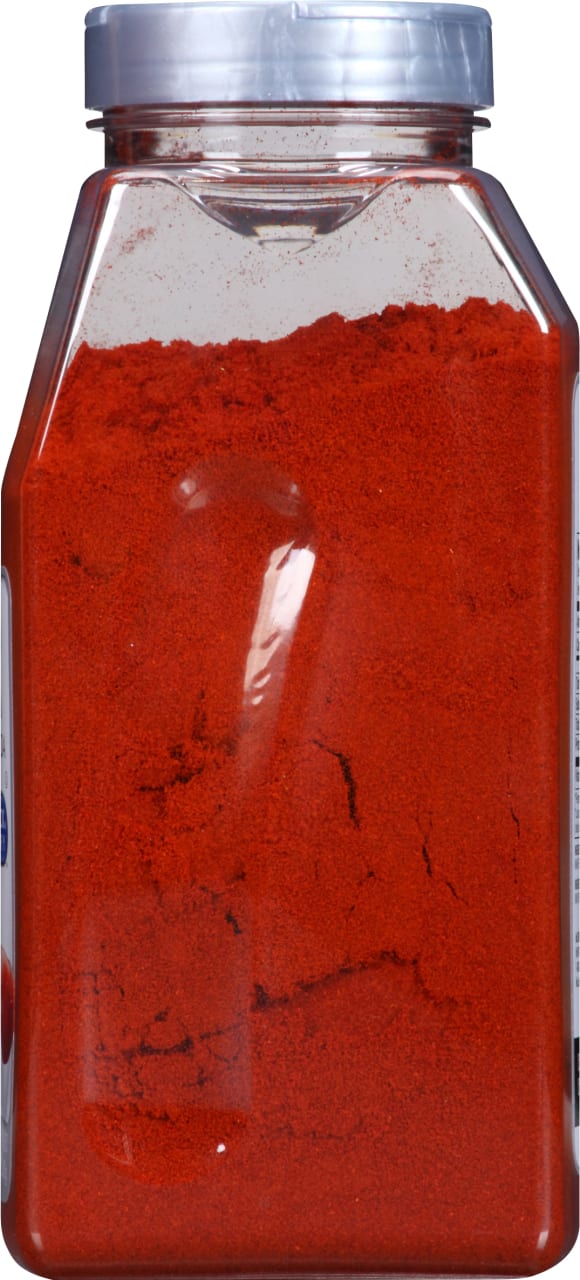 A clear plastic jar filled with red paprika powder.