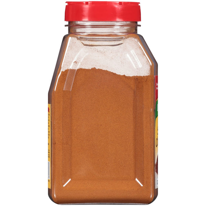 A glass jar with a red lid filled with ground cinnamon.
