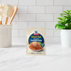 A packet of McCormick Sheet Pan Chicken Parmesan meal mix sits on a kitchen counter.