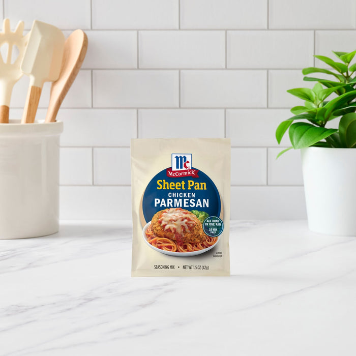 A packet of McCormick Sheet Pan Chicken Parmesan meal mix sits on a kitchen counter.