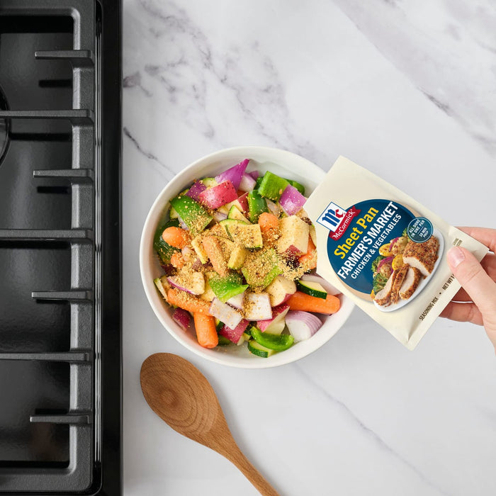 A hand pours Starkist Tuna Creations into a bowl of fresh vegetables.
