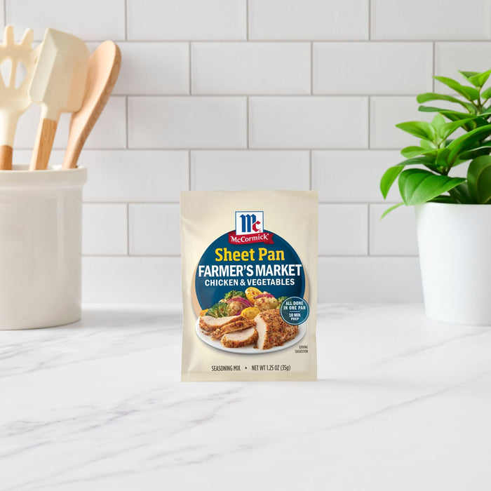 A packet of McCormick Sheet Pan Lemon Herb Chicken &amp; Veggies seasoning mix sits on a kitchen counter.