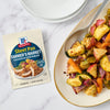 A package of McCormick Sheet Pan Farmer's Market Chicken &amp; Veggies seasoning mix is displayed next to a serving of the prepared dish.