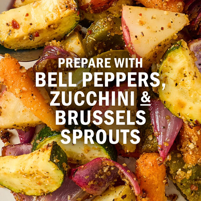 A close-up of roasted vegetables, including bell peppers, zucchini, and Brussels sprouts, seasoned and ready to eat.