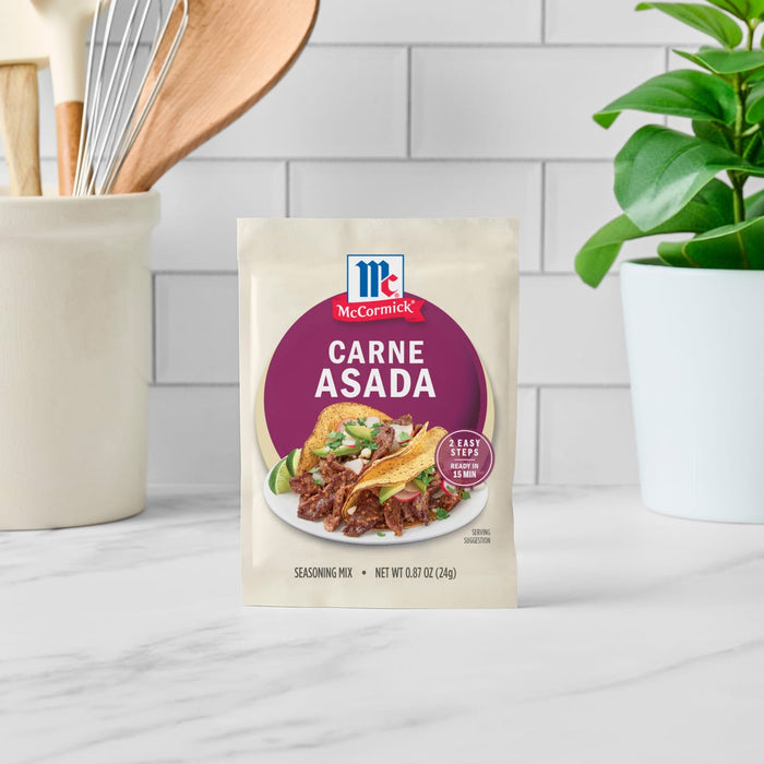 A packet of McCormick Carne Asada seasoning mix is displayed on a countertop.