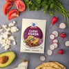 A packet of McCormick Carne Asada seasoning is surrounded by fresh ingredients like tomatoes, radishes, avocado, and cheese, suggesting a delicious meal.