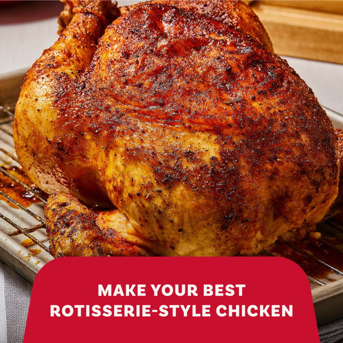 A whole roasted bird seasoned to perfection with Mccormick Perfect Pinch Rotisserie Chicken Seasoning Powder 5 Oz rests on a wire rack over a baking sheet.