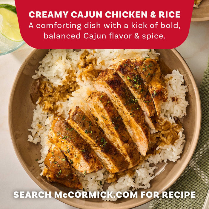 A bowl of Creamy Cajun Chicken and Rice prepared with Mccormick Perfect Pinch Cajun Seasoning Ground 5 Oz is shown in a top down view with a lime wedge and green napkin.