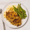 A plate of roasted chicken thighs and green beans served over mashed potatoes is seasoned with Mccormick Signature Seasoning Lemon Pepper Oz.