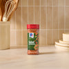 A bottle of Mccormick Signature Seasoning Salad Supreme Oz stands on a marble countertop in a bright kitchen setting.