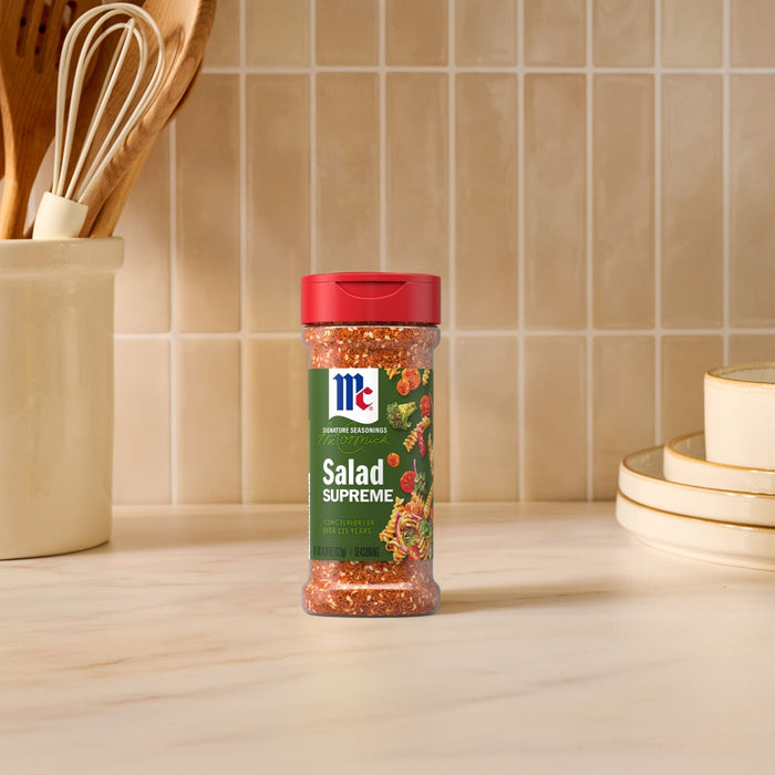 A bottle of Mccormick Signature Seasoning Salad Supreme Oz stands on a marble countertop in a bright kitchen setting.