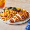 A plate of sliced grilled chicken and roasted zucchini is served alongside a vibrant corn salad seasoned with Mccormick Signature Seasoning Salad Supreme Oz.