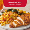 A plate of seasoned grilled chicken and zucchini served alongside a vibrant corn salad prepared with Mccormick Signature Seasoning Salad Supreme Oz under the heading Make Your Best Grilled Dishes.