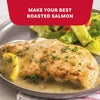 A plate of roasted salmon topped with a savory sauce and fresh herbs prepared with Mccormick Garlic And Herb Seasoning Ground 4.37 Oz alongside a fresh green salad.
