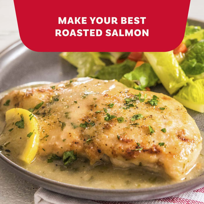 A plate of roasted salmon topped with a savory sauce and fresh herbs prepared with Mccormick Garlic And Herb Seasoning Ground 4.37 Oz alongside a fresh green salad.