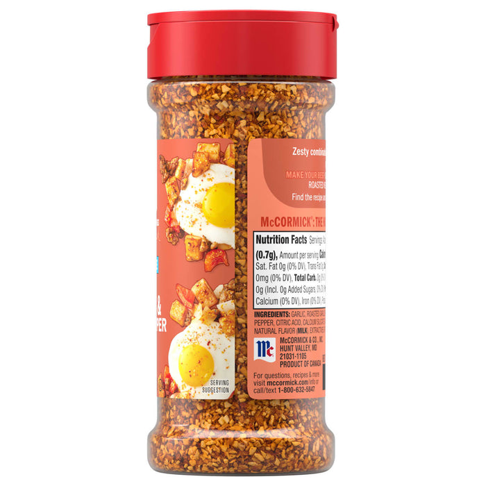 A clear plastic bottle of Mccormick Roasted Garlic And Red Bell Pepper Seasoning Ground 4.34 Oz featuring a red cap and a label showing a serving suggestion of seasoned eggs and potatoes.