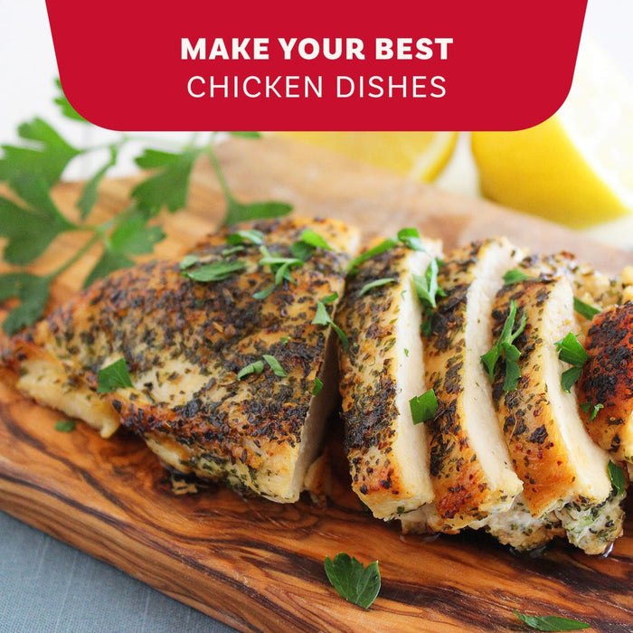 A sliced chicken breast seasoned with Mccormick Onion And Herb Seasoning Crystal 4.16 Oz rests on a wooden cutting board garnished with fresh parsley and lemon.